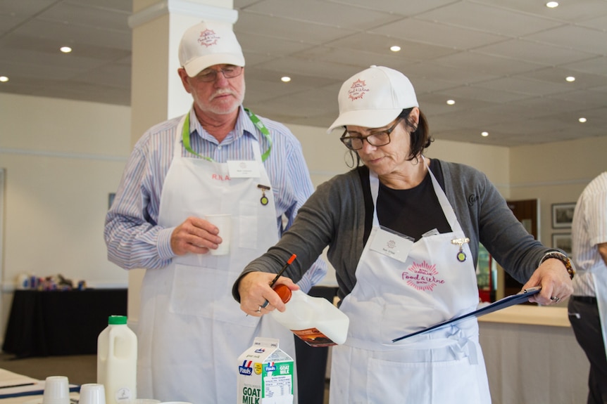 Judges look at the details on the camel milk after testing.