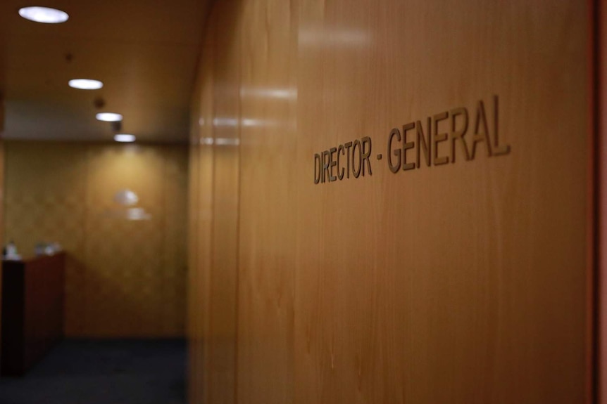 A wood-panelled wall with the words director-general on it.