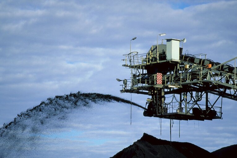 La bande transporteuse de la mine pulvérise du charbon dans l'air dans un tas creusé dans une mine à Oaky Creek près de Middlemount dans le centre de Qld