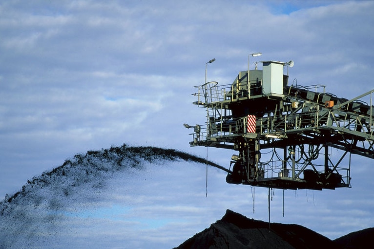 Mine conveyor belt sprays coal in the air into a pile dug from a mine at Oaky Creek near Middlemount in central Qld