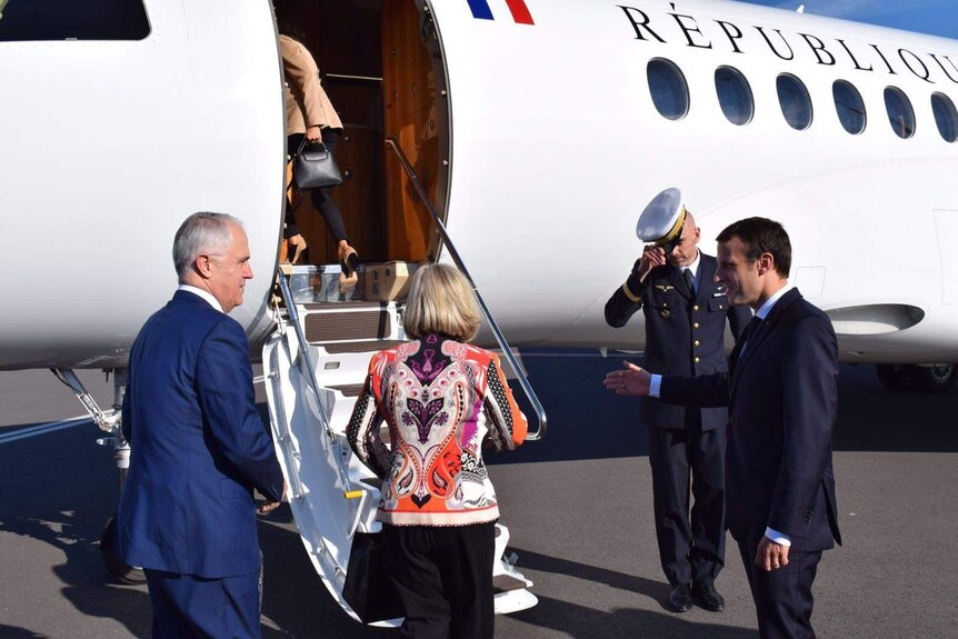 Malcolm Turnbull and his wife Lucy are welcomed by French President Emmanuel Macron onto his private plane.
