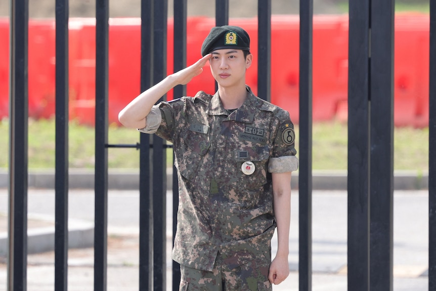 Yin wearing military uniform and beret saluting
