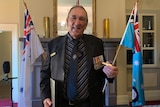 Patrick Halley wears medals and holds his Gunner's Wings medal