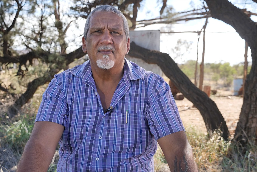 Senior Alyawerre man from Central Australia Michael Liddle sits outside.