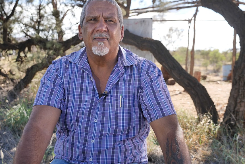 Senior Alyawerre man from Central Australia Michael Liddle sits outside.