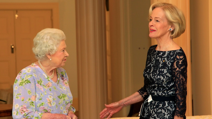governor general quentin bryce speaks to the queen in a warmly-lit sitting room