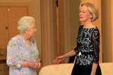 governor general quentin bryce speaks to the queen in a warmly-lit sitting room