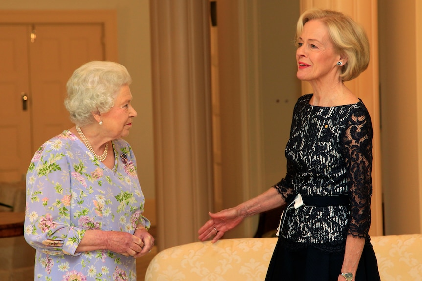 governor general quentin bryce speaks to the queen in a warmly-lit sitting room