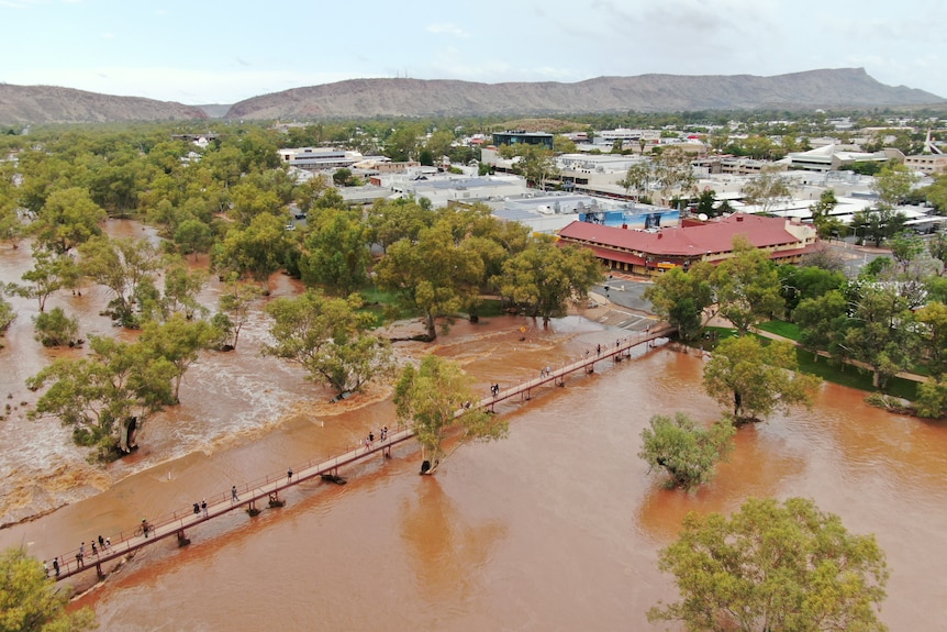 aerial shot of flooded river, trees and town buildings 