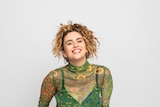 image of woman with curly hair in green shirt smiling