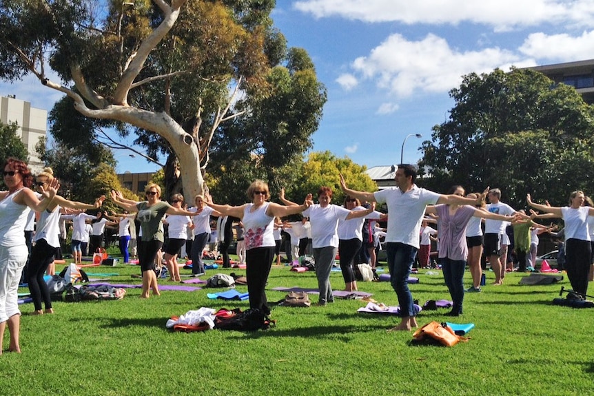 Hands raised in unison during yoga in Adelaide