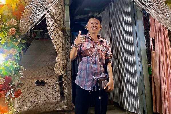 A Vietnamese woman with short hair smiling with a thumbs up 