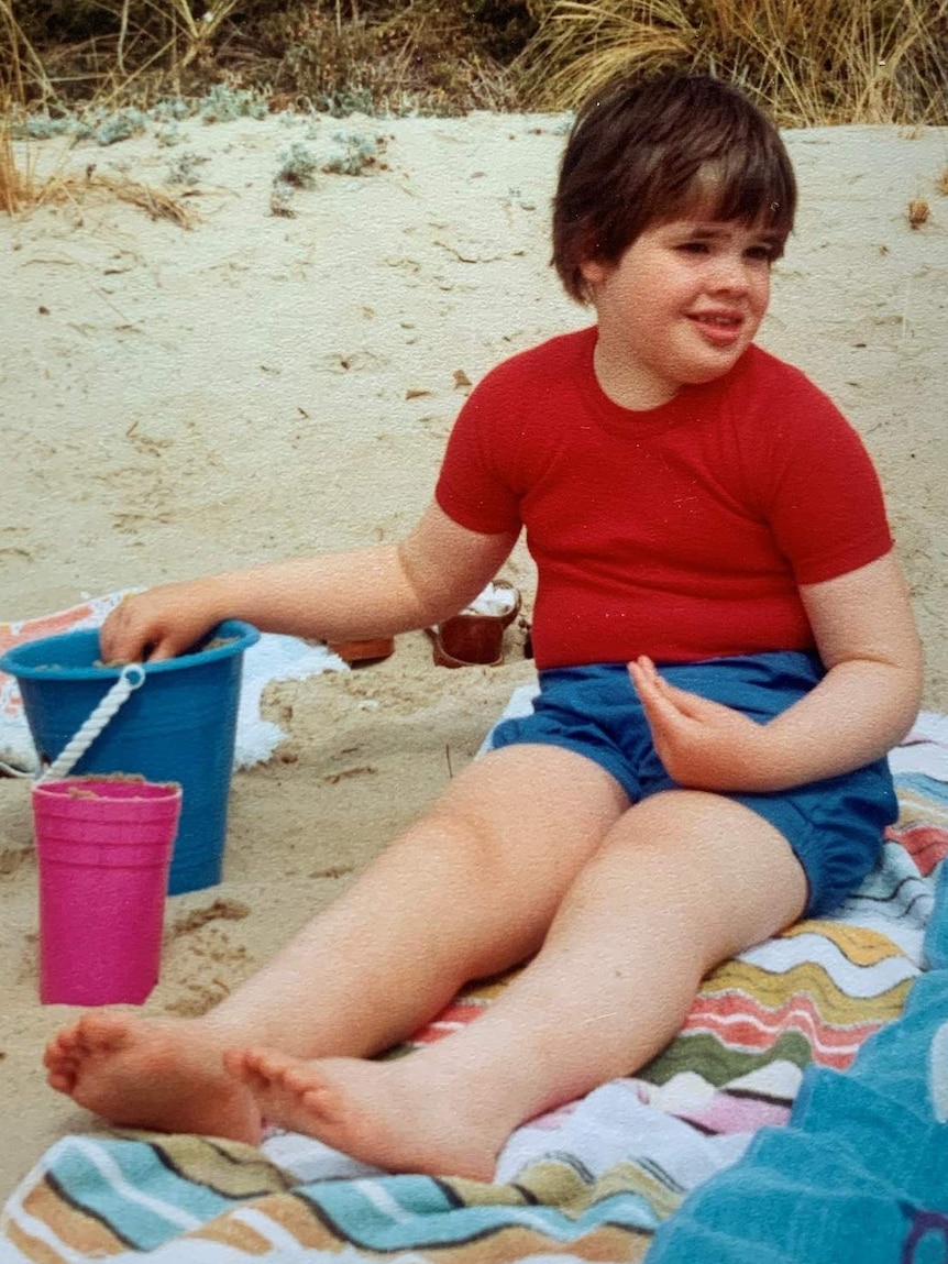 A child sitting on a beach towel.