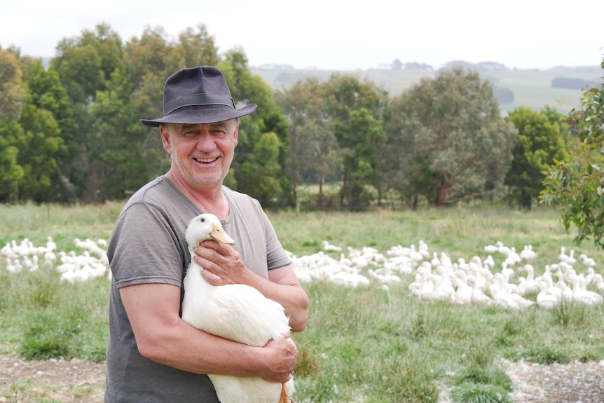 A man holding a white duck