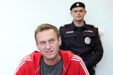 Alexei Navalny is pictured smirking in a Moscow court with police behind him in this 2019 file photo.