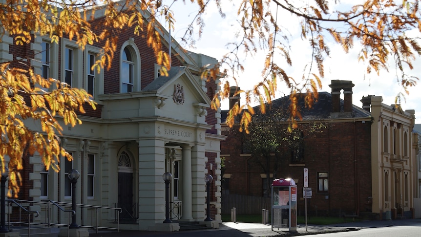 A heritage court building exterior with out-of-focus autumn leaves in the foreground
