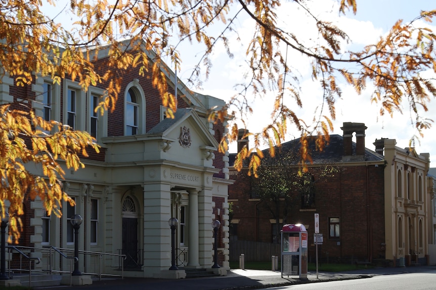 A heritage court building exterior with out-of-focus autumn leaves in the foreground