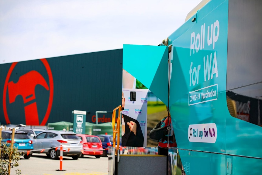 A close-up of a Roll up for WA bus with open door and a Bunnings store in the background.
