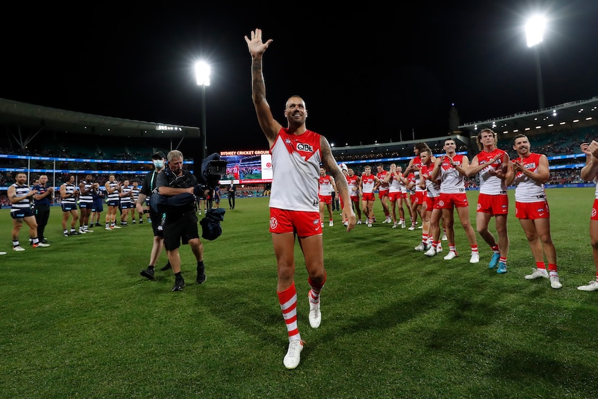 AFL star Lance Franklin waves to the crowd as his Sydney team and Geelong opposition applaud him off the SCG. 