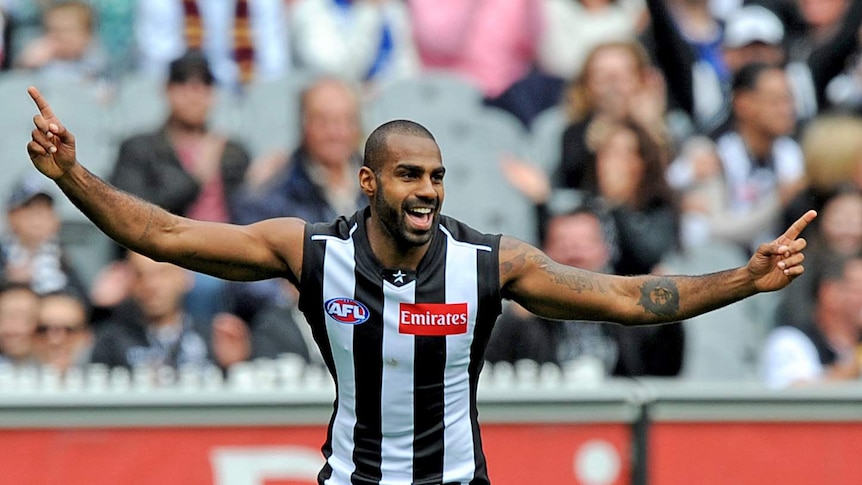 Heritier Lumumba smiles and celebrates with arms wide.