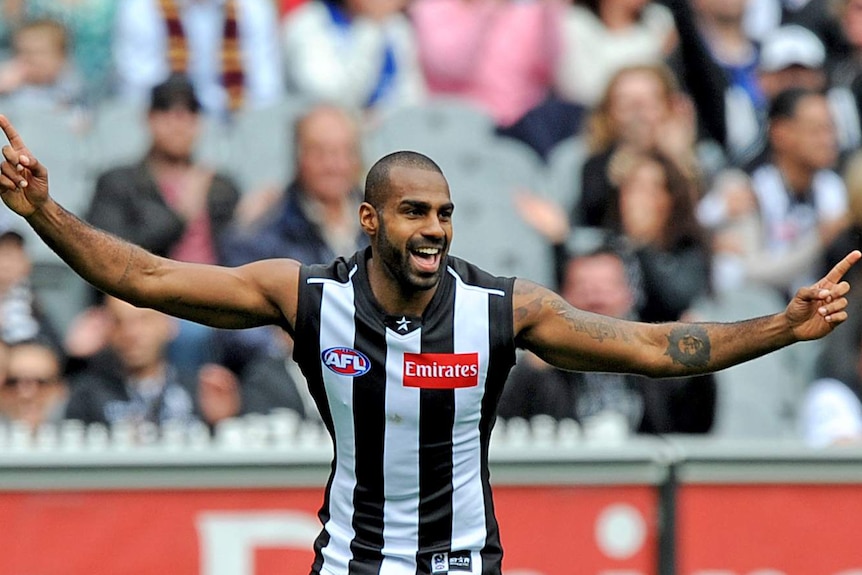 Heritier Lumumba smiles and celebrates with arms wide.