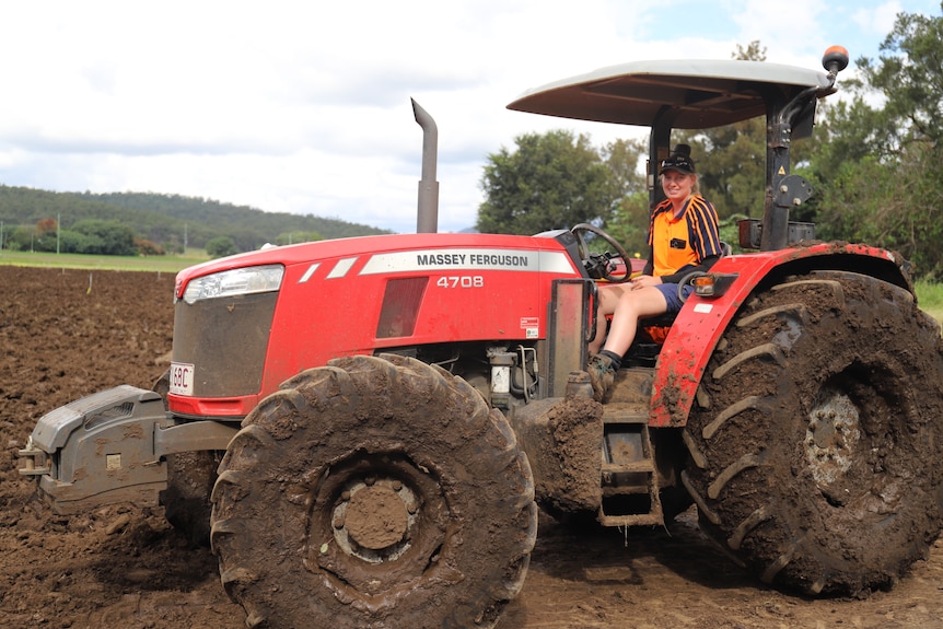 Bridget Mackenzie sits on a tractor in a muddy paddock in the Lockyer Valley.