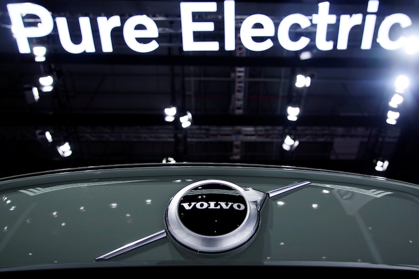 A Pure Electric sign is seen above a Volvo vehicle.