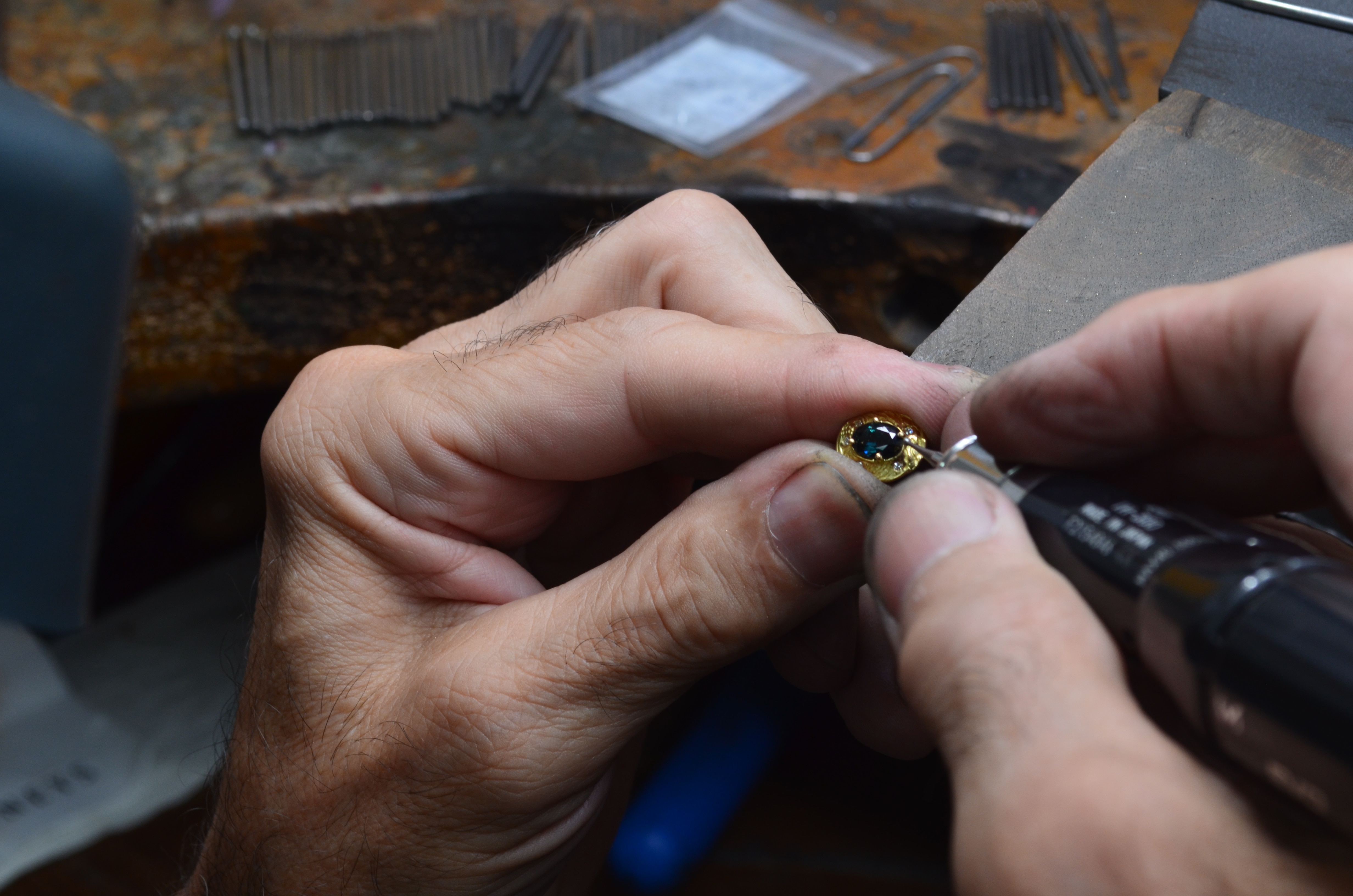Um joalheiro de mesa está fazendo um brinco de diamante natural. 