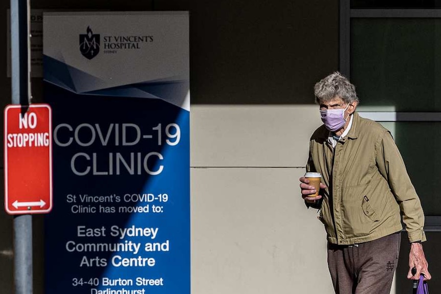 A man wearing a face mask and a woman walk outside of a Sydney hospital.