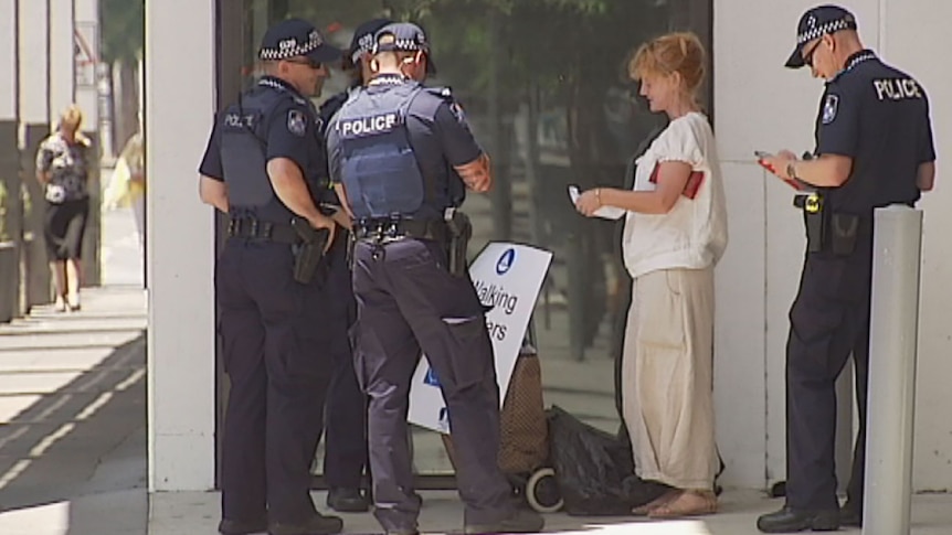 Police tell a lone protester outside the Brisbane Convention Centre to move on Saturday November 1 after the area became a restricted zone.