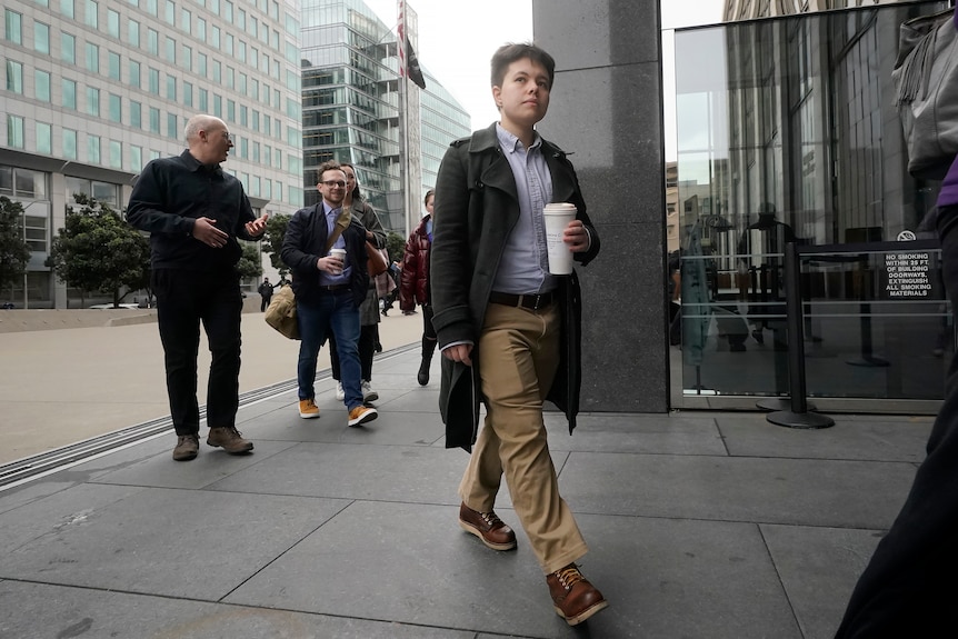 Justine de Caires walks into a courthouse with other people following behind. 