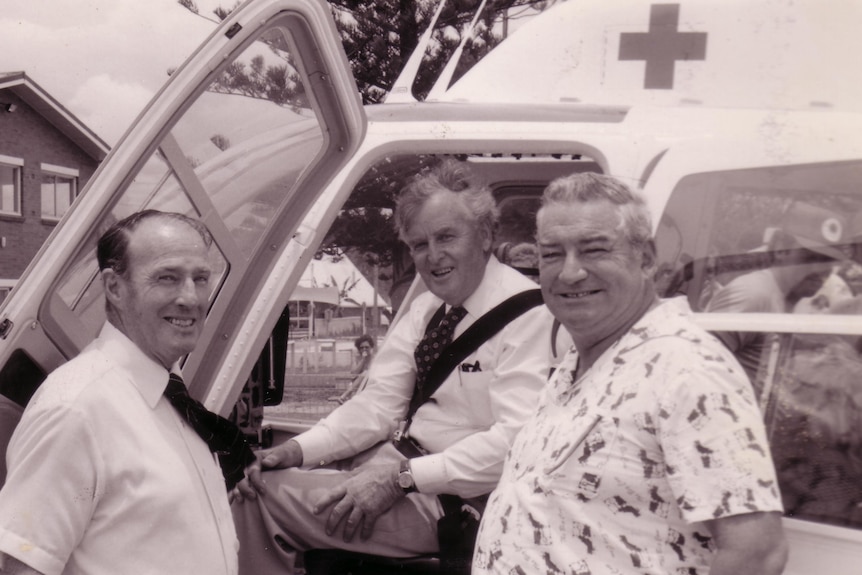 Unknown man on the left, Jo Bjelke-Petersen sitting in helicopter, Des Scanlan to right.
