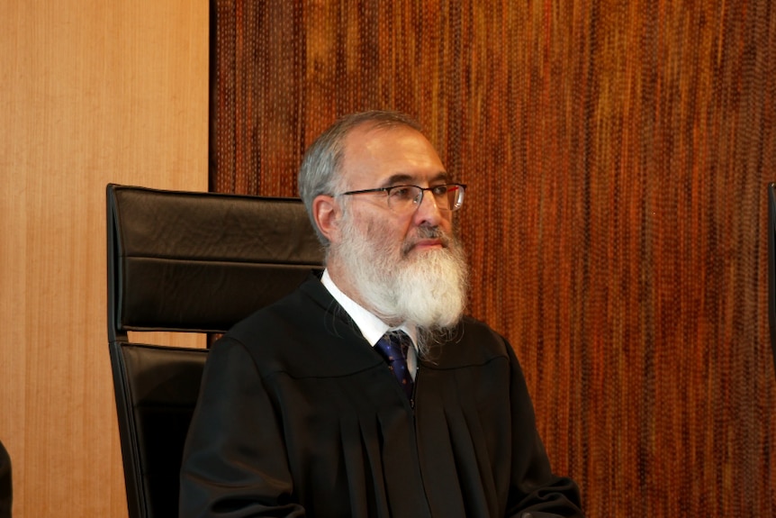 A robed, bearded judge sits in the dock of the WA Supreme Court