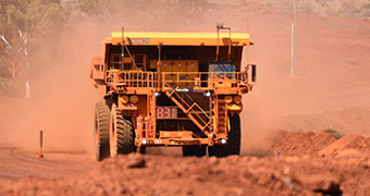 A driverless truck travelling on a dirt road.