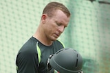 Chris Rogers checks his helmet at training