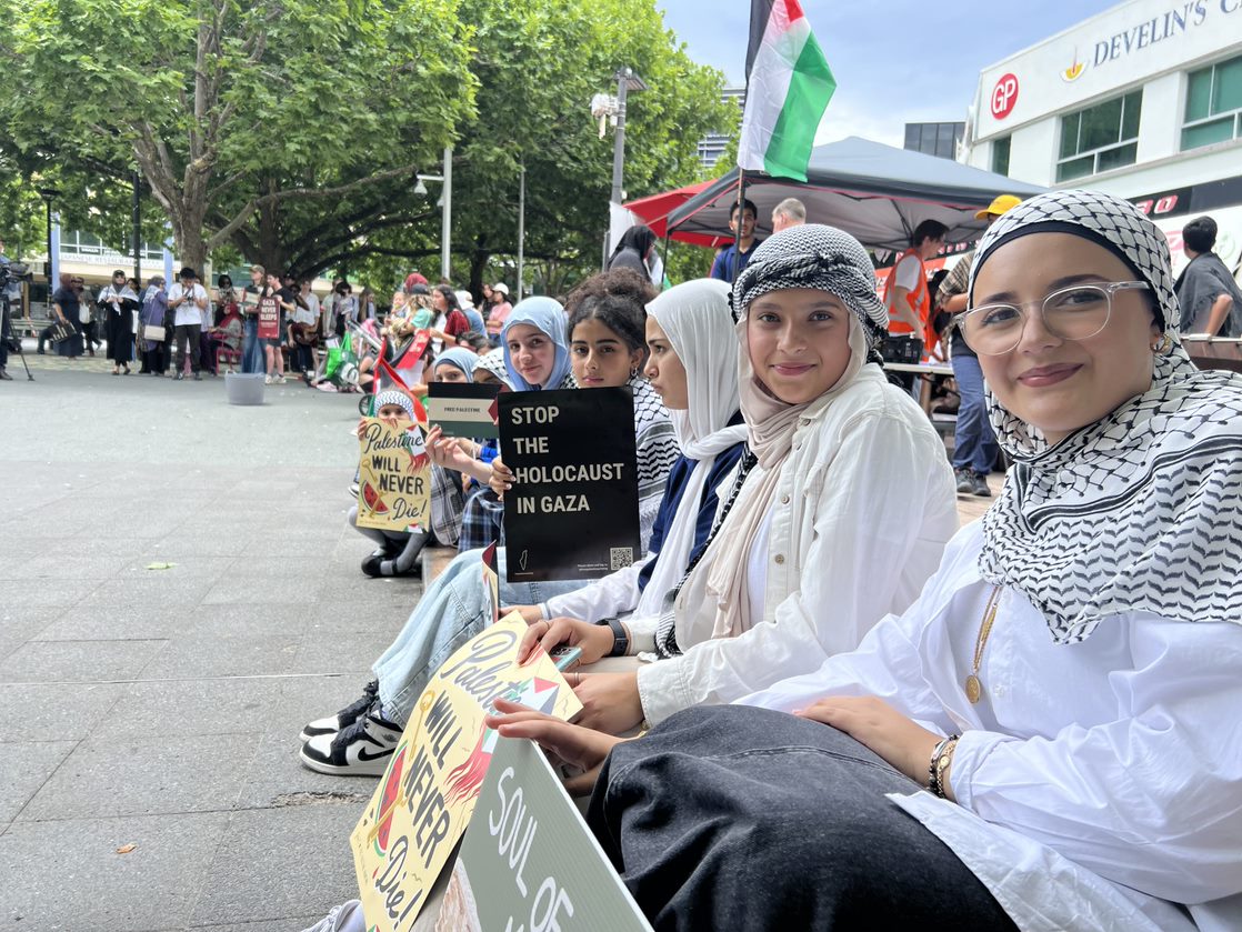 People holding signs in Canberra's city centre as part of a School Strike for Palestine.