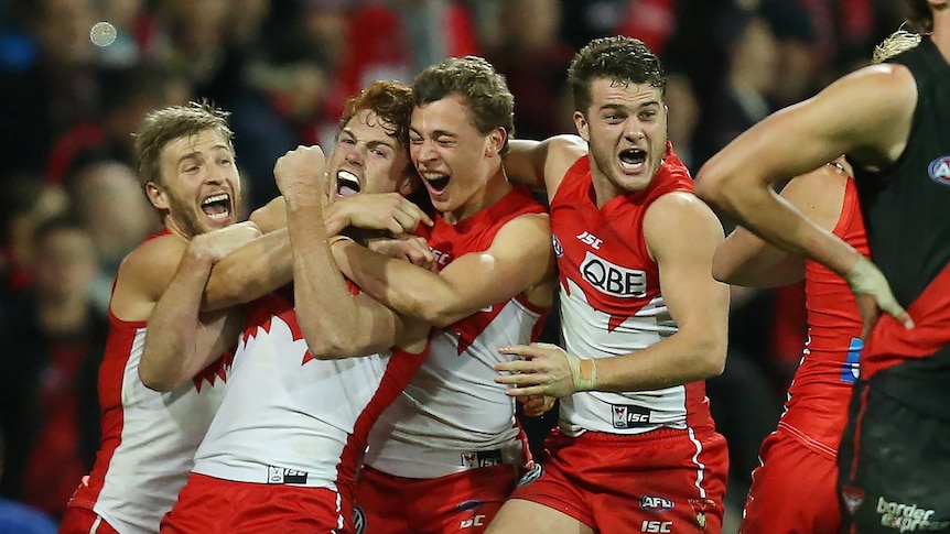 Gary Rohan of the Swans (2nd left) celebrates with his team mates.