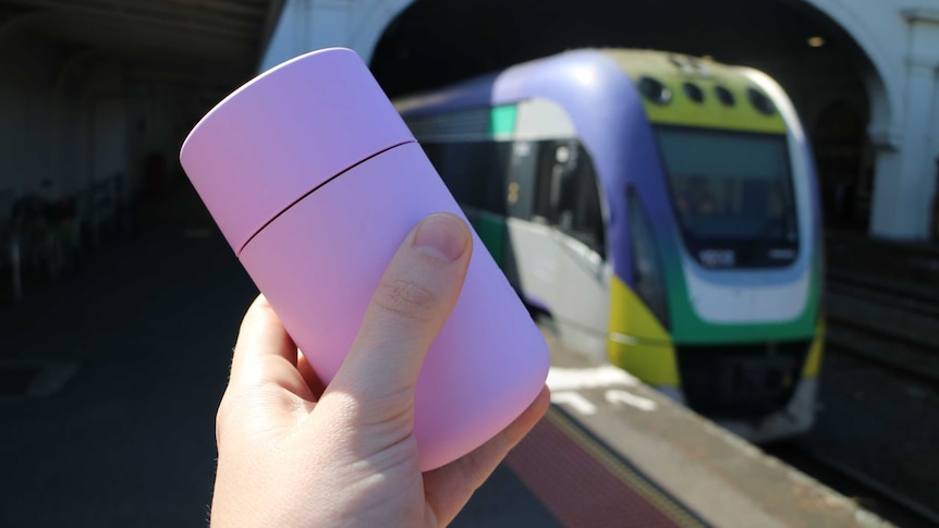 good generic shot of a pink keep cup being held in front of train
