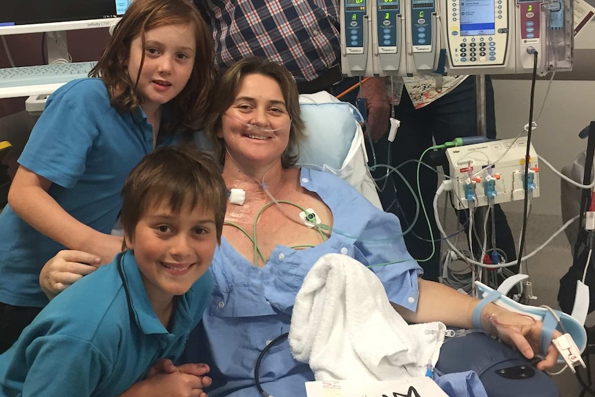 Jo Dean being treated in hospital with her two children.