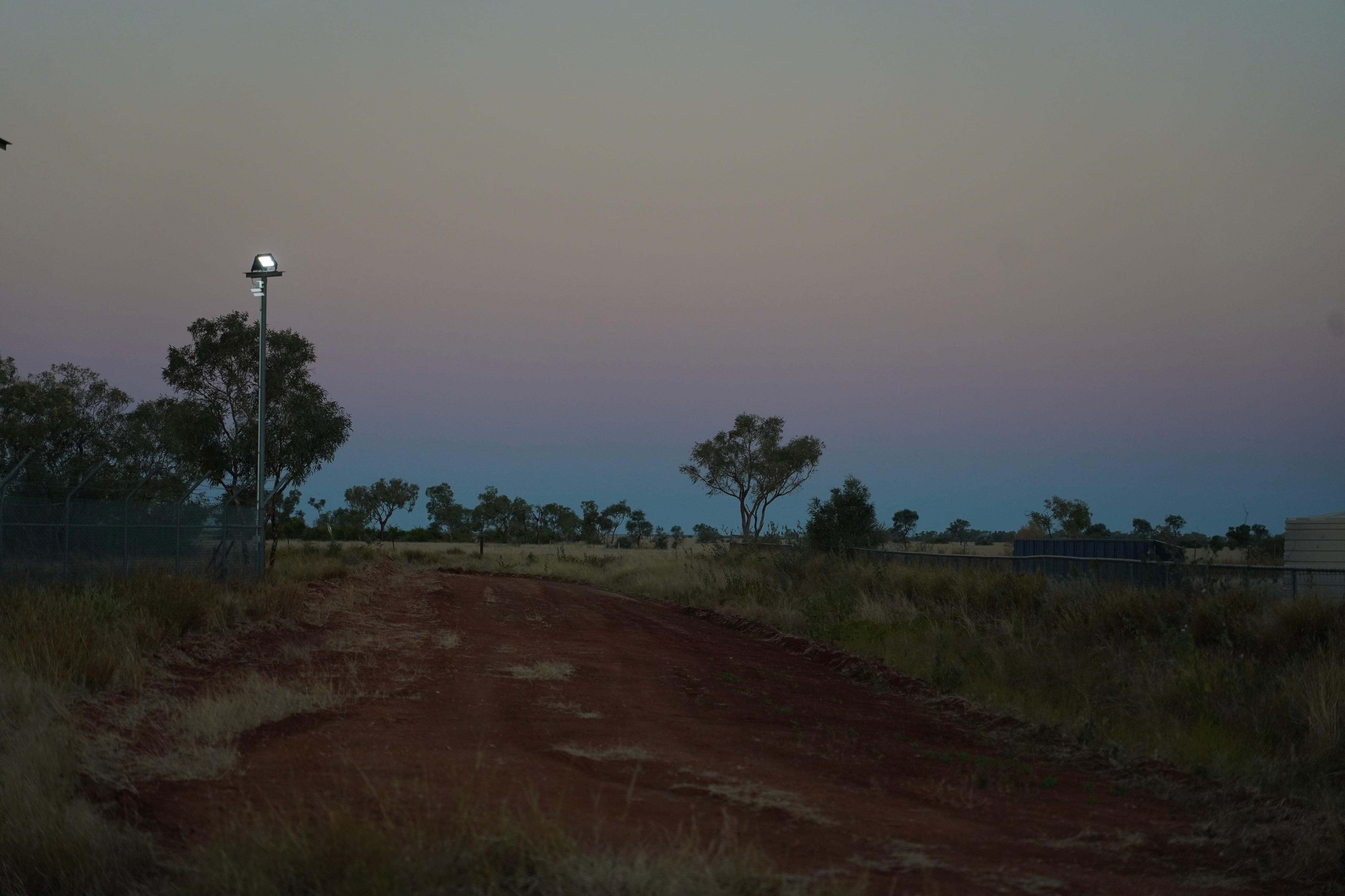 Sunset with blues, pinks and purples over red dirt road