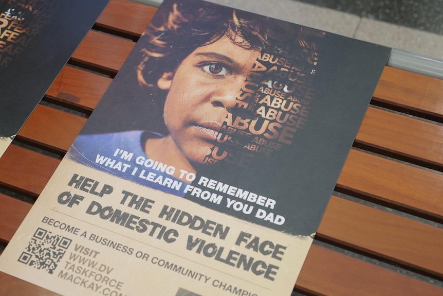 A poster for a domestic violence campaign on a public seat. 
