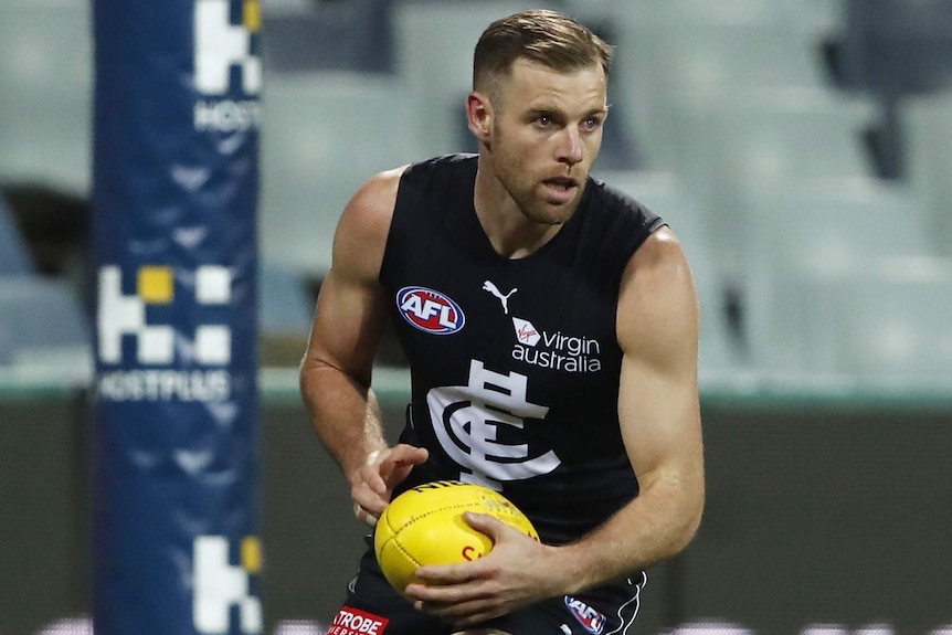 A Carlton Blues AFL player holds the ball during a match against the Cats in Geelong.