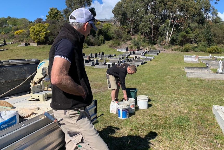 Harvey Jones leaning against the back of a trailer, watching on as a colleague mixes cement. 