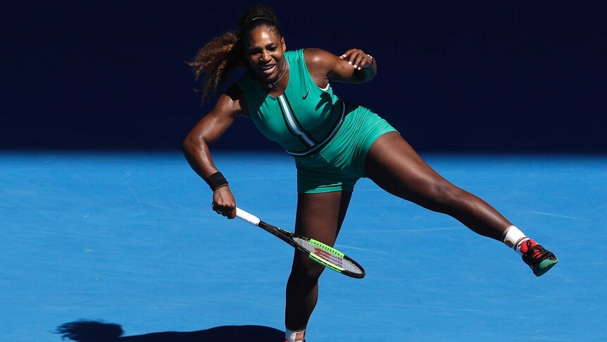 Serena Williams plays an awkward forehand while standing on one leg with a pained look on her face at the Australian Open.
