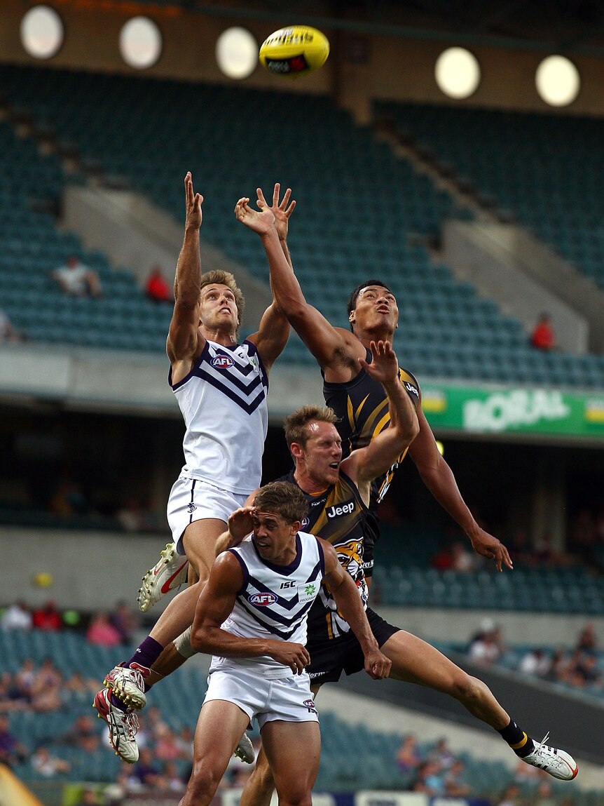 Matt de Boer of the Dockers and Piva Wright of the Tigers fly high in the west.