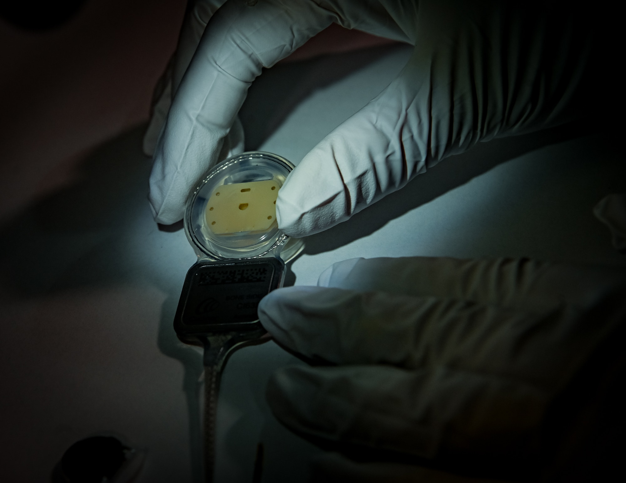 A hand holding a Cochlear implant.