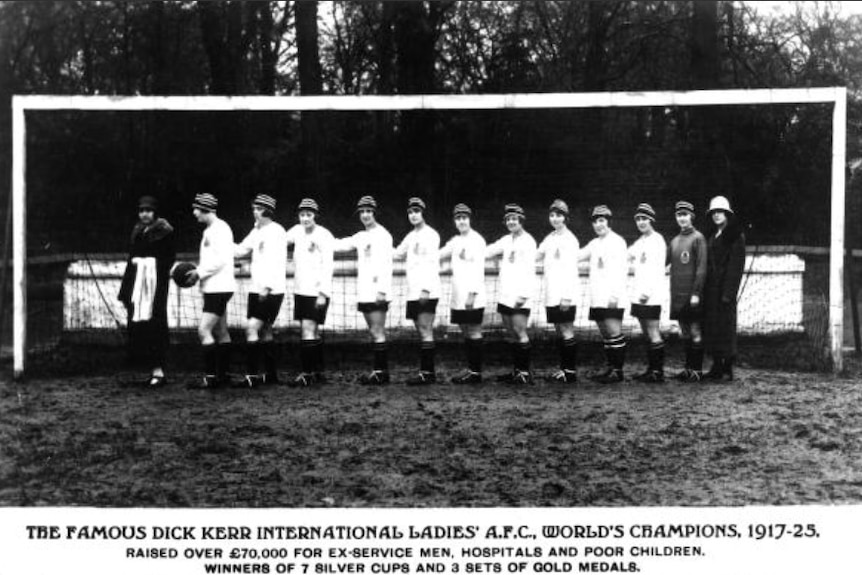 Dick Kerr Ladies line up in front of a goal