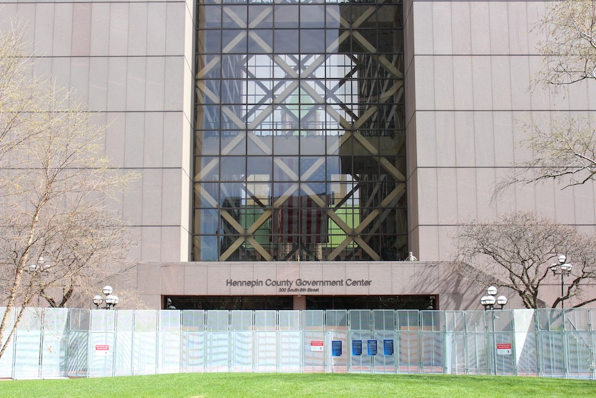 The exterior of a court building with fences around the entrance