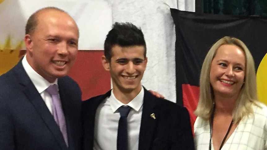 Peter Dutton smiles with Yazidi teen Haji Ilya and another woman and man
