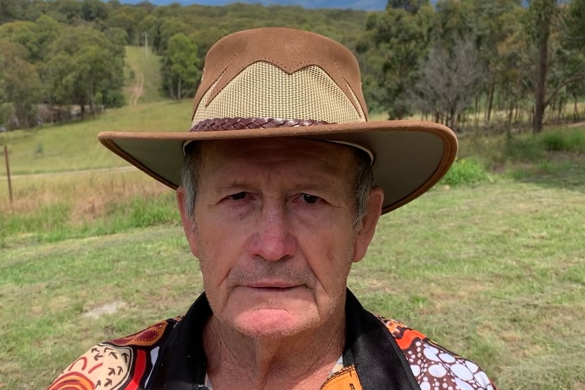 A middle aged man in a hat in the bush